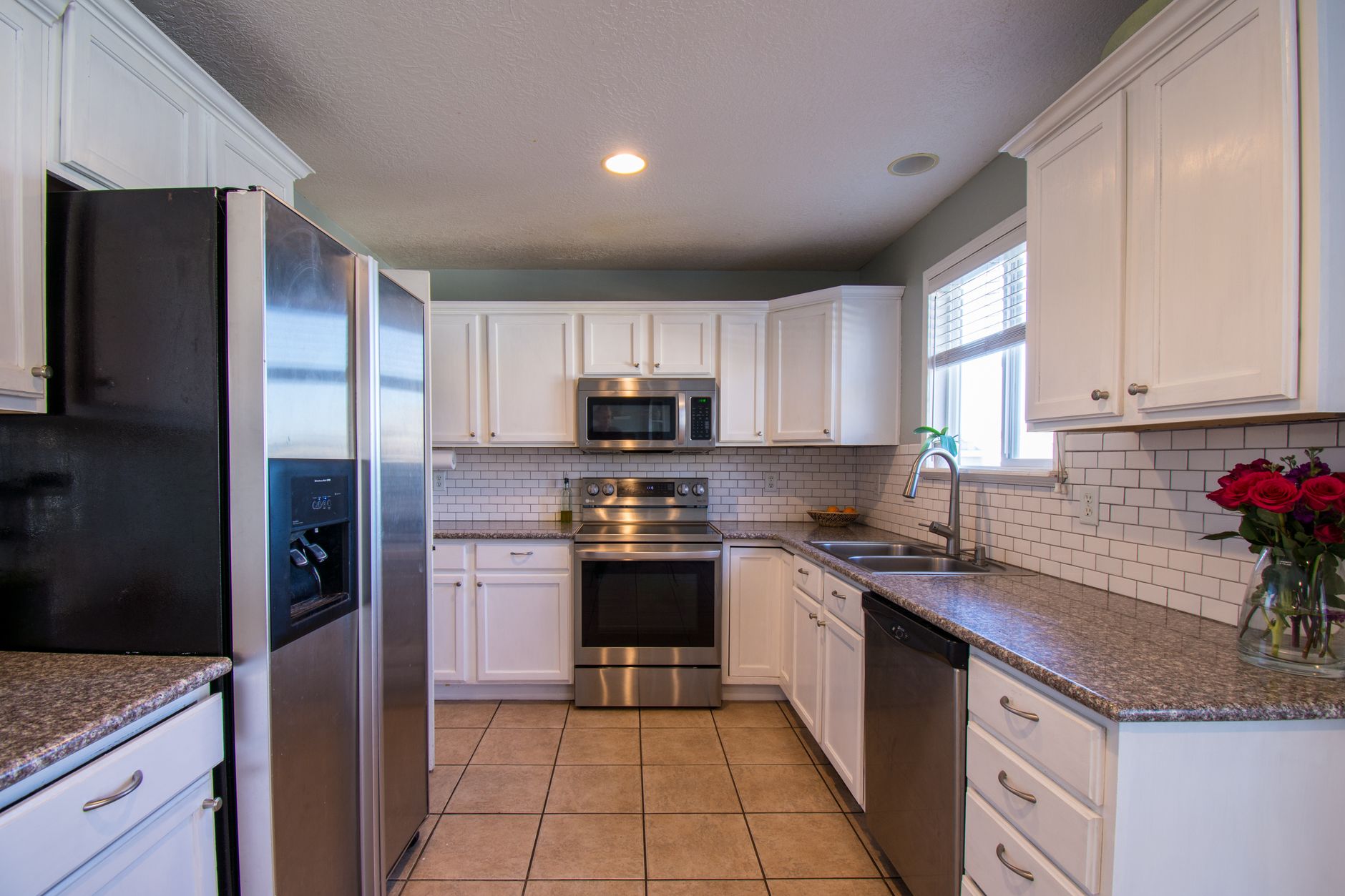 A bright kitchen featuring white cabinetry and stainless steel appliances in Bellevue, WA
